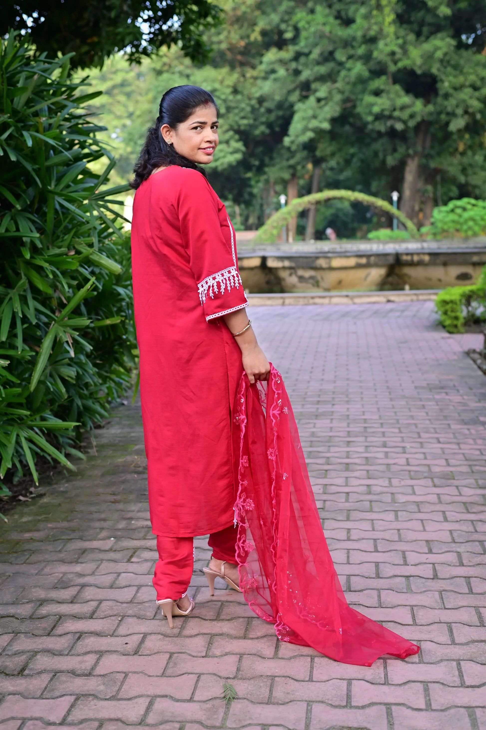 Back view of red kurta pant set with white embroidery and net dupatta